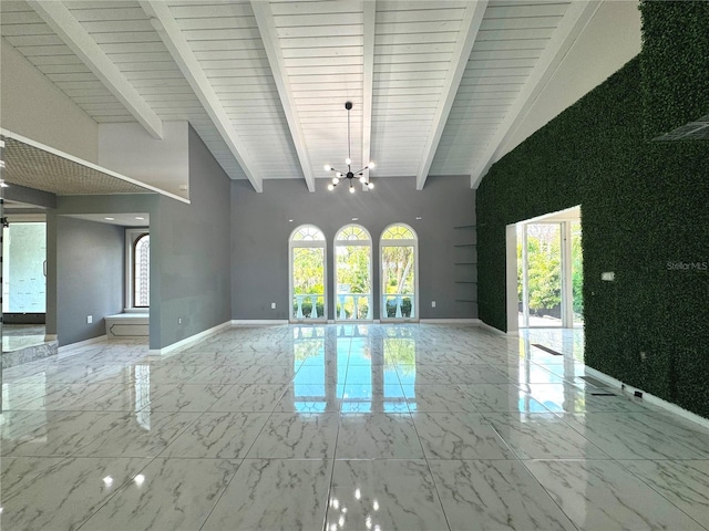 spare room featuring beamed ceiling, light tile patterned floors, a wealth of natural light, and an inviting chandelier