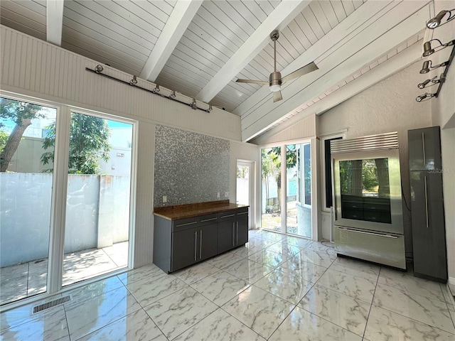 kitchen with beam ceiling, light tile patterned floors, ceiling fan, and a healthy amount of sunlight