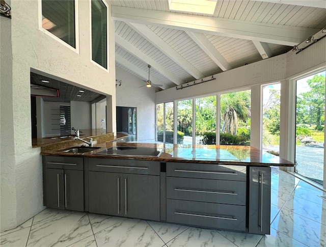 kitchen featuring light tile patterned flooring, gray cabinets, cooktop, and ceiling fan