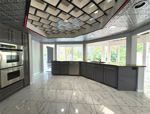 kitchen featuring light tile patterned flooring, appliances with stainless steel finishes, a healthy amount of sunlight, and sink