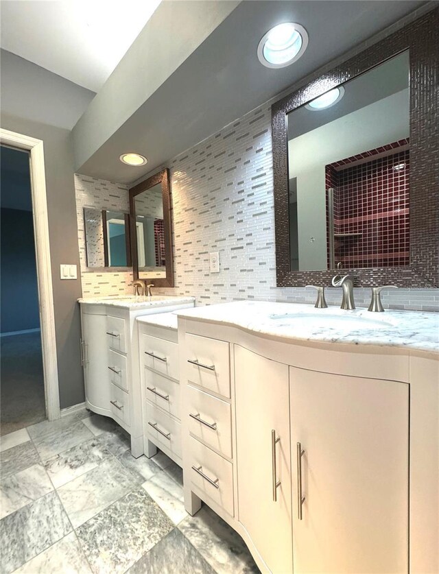 bathroom with tile patterned floors, dual bowl vanity, and decorative backsplash