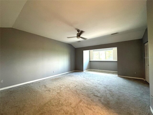 carpeted empty room with ceiling fan and vaulted ceiling