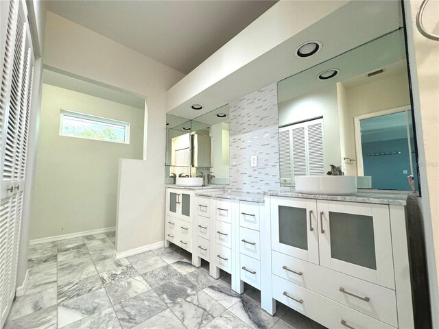 bathroom with tasteful backsplash, tile patterned floors, and double vanity