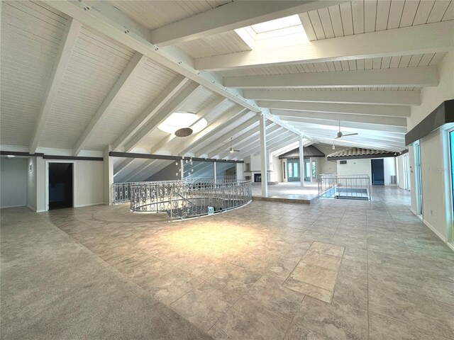 interior space featuring vaulted ceiling with skylight, tile patterned floors, and ceiling fan