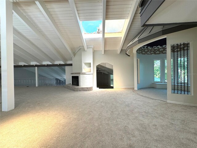 unfurnished living room with vaulted ceiling with beams, built in features, and carpet floors