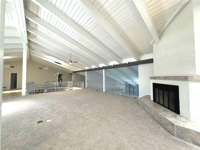 unfurnished living room featuring ceiling fan, carpet flooring, lofted ceiling with beams, and a large fireplace