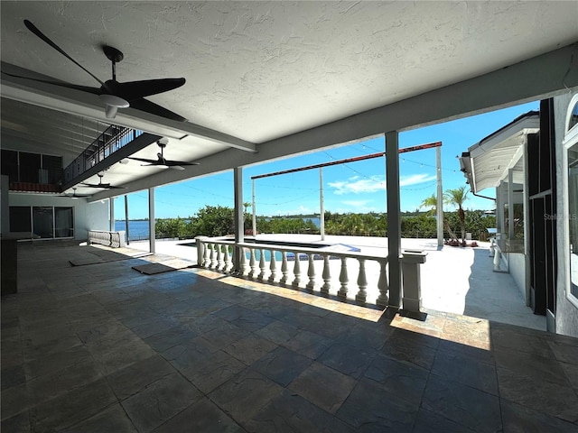 view of pool with ceiling fan, a patio area, and a water view