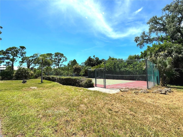 view of basketball court featuring tennis court and a lawn