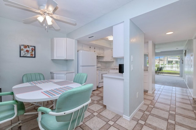 carpeted dining area with ceiling fan