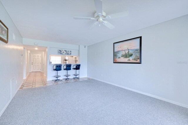 unfurnished living room featuring light carpet and ceiling fan