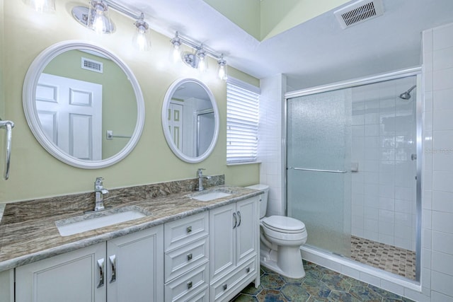 bathroom featuring dual bowl vanity, a shower with door, tile patterned flooring, and toilet