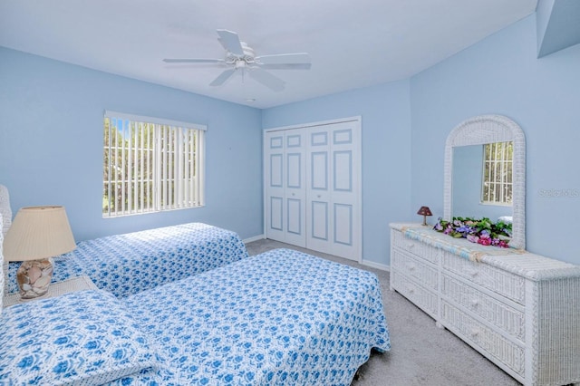 bedroom featuring light colored carpet, a closet, and ceiling fan