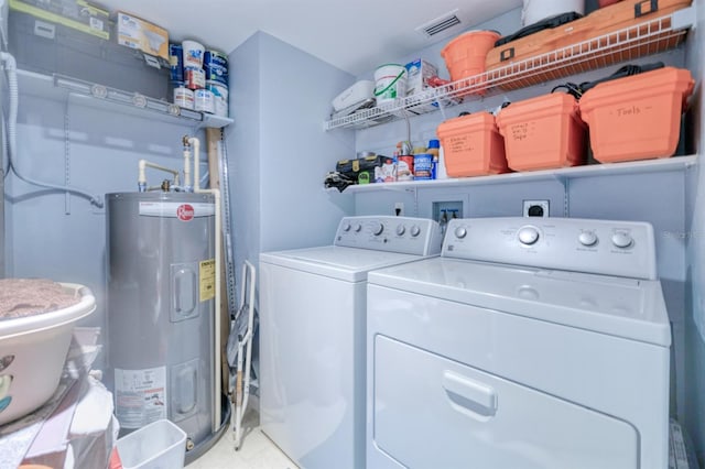 washroom with electric water heater and washer and dryer