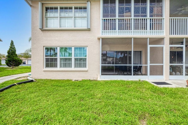 back of property with a yard and a balcony