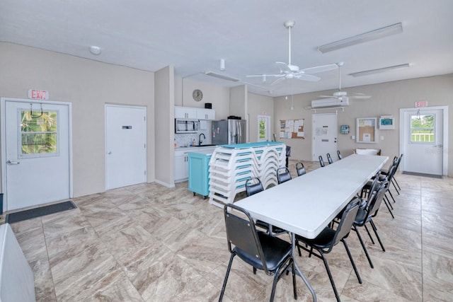 dining area featuring light tile patterned flooring, sink, and ceiling fan