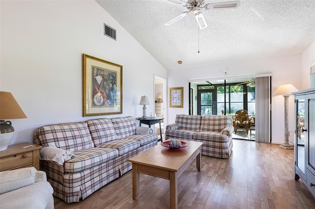 living room featuring a textured ceiling, wood-type flooring, ceiling fan, and high vaulted ceiling