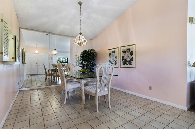 tiled dining area featuring vaulted ceiling, a chandelier, and a textured ceiling