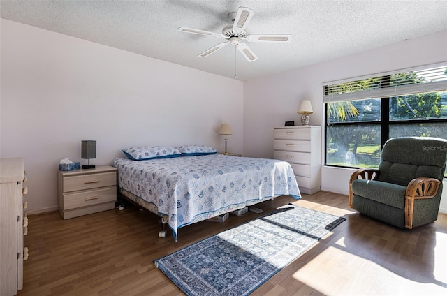 bedroom featuring ceiling fan, a textured ceiling, and hardwood / wood-style floors