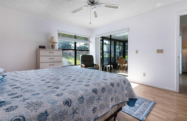 bedroom with ceiling fan, access to outside, a textured ceiling, and light hardwood / wood-style floors