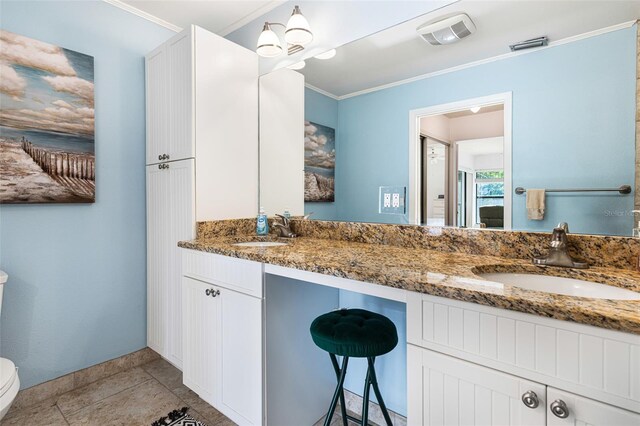 bathroom with ornamental molding, tile patterned floors, dual vanity, and toilet