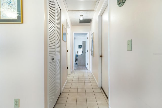 hallway with light tile patterned floors and a textured ceiling