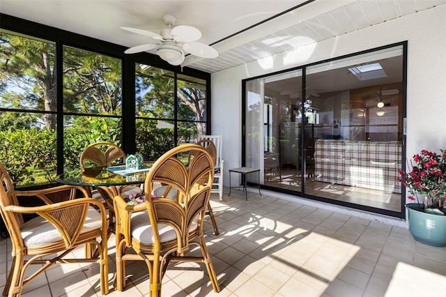 sunroom / solarium featuring ceiling fan and a skylight