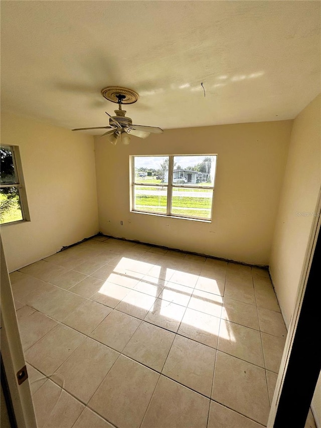 empty room with light tile patterned floors and ceiling fan