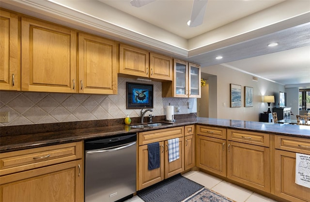 kitchen featuring sink, light tile patterned floors, dishwasher, kitchen peninsula, and dark stone counters