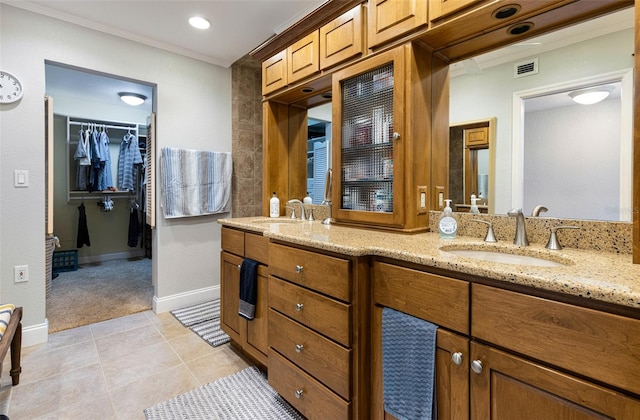 bathroom with tile patterned flooring, vanity, and crown molding