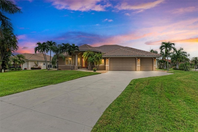 mediterranean / spanish house featuring a garage and a lawn