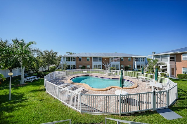 view of swimming pool with a patio and a yard