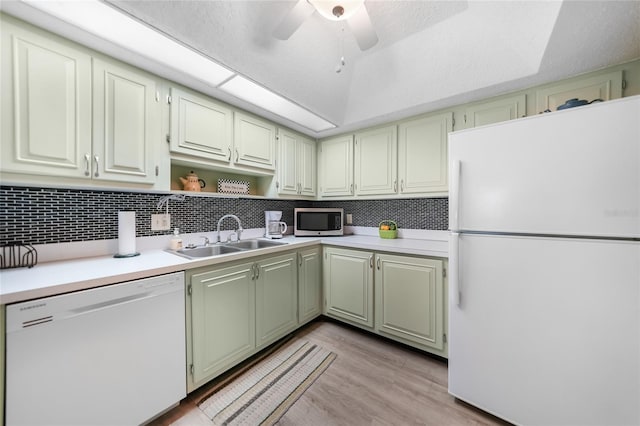 kitchen with white appliances, light hardwood / wood-style flooring, backsplash, ceiling fan, and sink