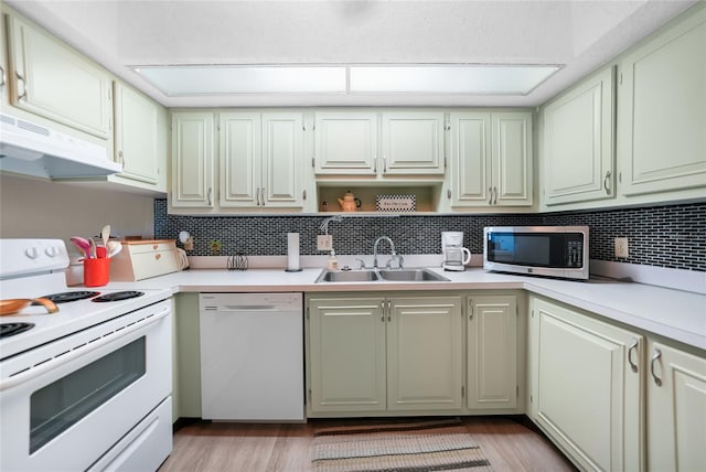 kitchen with sink, light hardwood / wood-style flooring, white appliances, and decorative backsplash