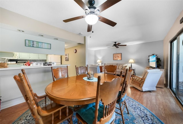 dining room with ceiling fan and light wood-type flooring