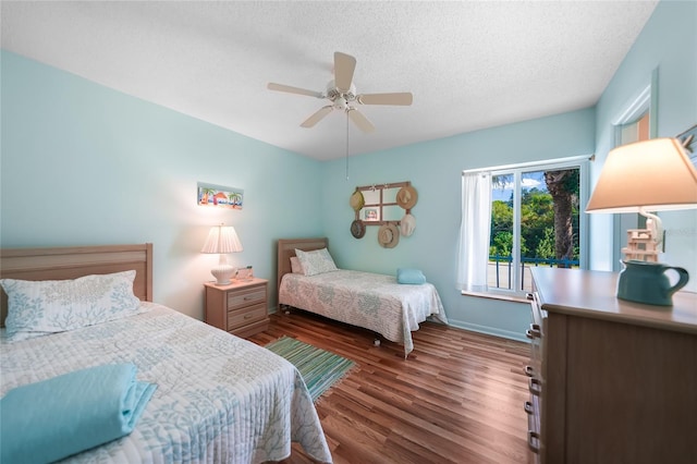 bedroom with a ceiling fan, a textured ceiling, baseboards, and wood finished floors