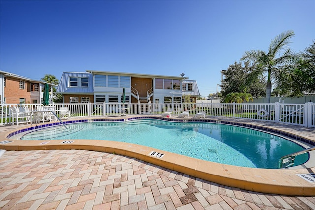 community pool featuring fence and a patio