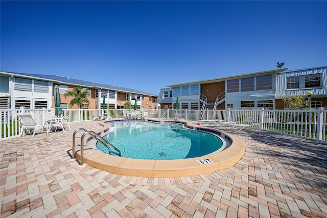 community pool featuring a patio and fence