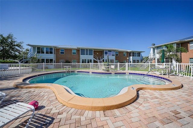 pool featuring fence and a patio