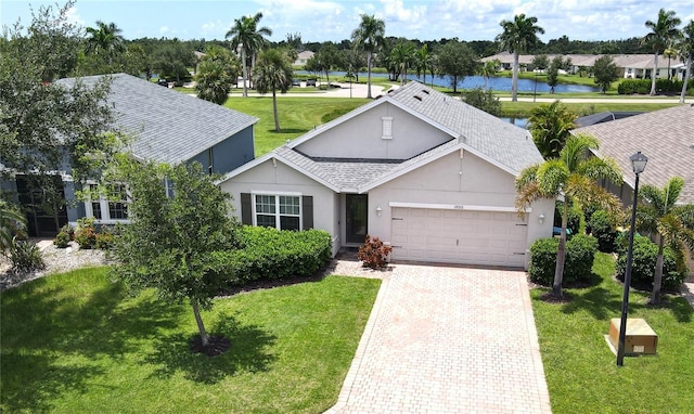 ranch-style house with a water view, a garage, and a front lawn