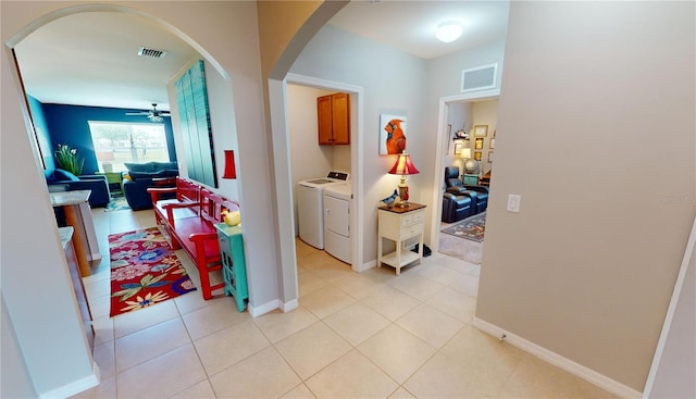 corridor with light tile patterned floors and washer and clothes dryer