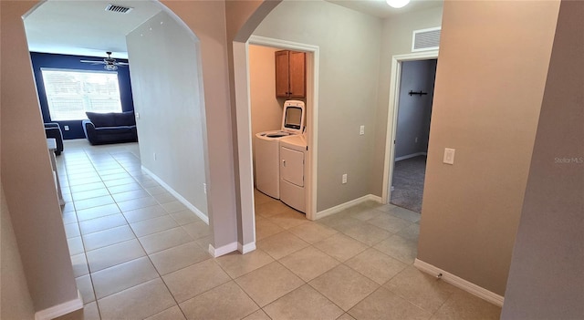 hallway with washer and dryer and light tile patterned floors