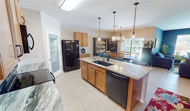 kitchen with black appliances, sink, an island with sink, and a wealth of natural light