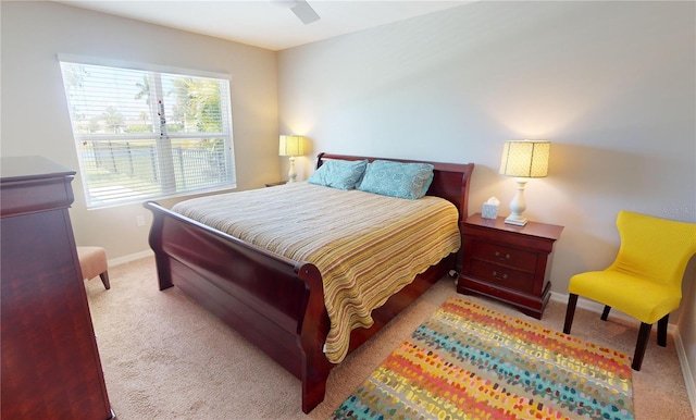 bedroom featuring ceiling fan, light colored carpet, and multiple windows