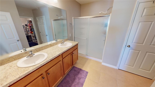 bathroom with tile patterned flooring, vanity, and a shower with door