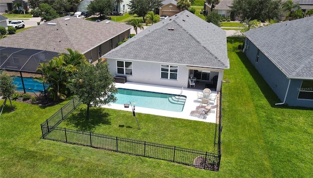 view of swimming pool with a yard, a patio, and glass enclosure