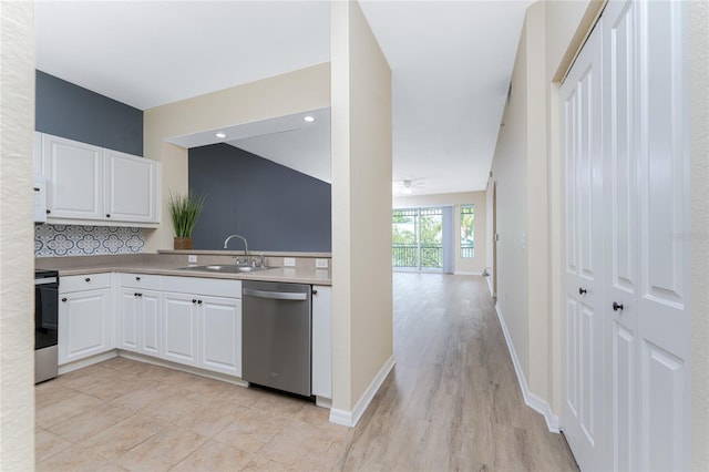 kitchen featuring white cabinetry, stainless steel dishwasher, sink, light wood-type flooring, and stove