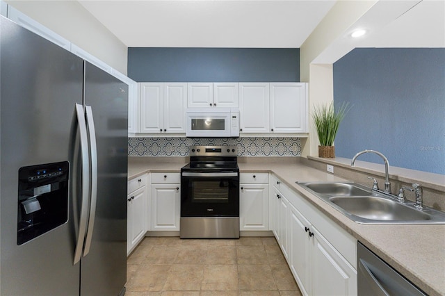 kitchen with backsplash, white cabinetry, light tile patterned floors, sink, and stainless steel appliances