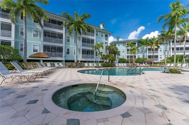 view of swimming pool featuring a hot tub and a patio