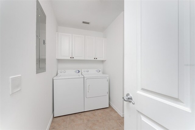 laundry room with independent washer and dryer, light tile patterned flooring, and cabinets