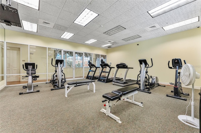 exercise room featuring carpet flooring and a drop ceiling